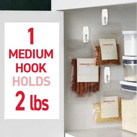 Medium Wire Toggle Hooks Set With 7 Wall Hooks And 8 Adhesive Strips For Damage Free Hanging, holding spice bags on kitchen wall.