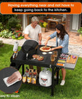 Heavy Duty Pizza Oven Table With Topping Station On Wheels Gigantic Countertop Cart For Large Pizzas And Outdoor Grillin Fits Big Ovens And Most Cart Sizes Easy Assembly Stable Stand For Parties shown in a backyard setting with two people making pizza.