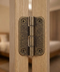 Close-up of 1.4 inch antique bronze hinge mounted on wooden cabinet, part of 12 Pack Small Iron Hinges With Rounded Corners Four Hole Vertical Mount.