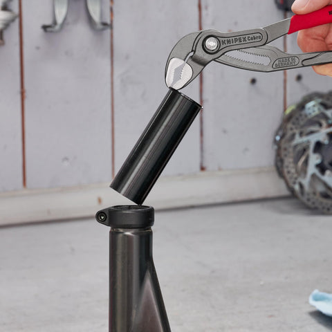 Cobra Water Pump Pliers, 10 Inch, showing adjustable jaw gripping a black pipe for heavy duty plumbing, quick fine adjustment