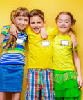 Three kids wearing 180 pieces boho name tag stickers for classroom use dope heart and polka dot labels for teachers and students