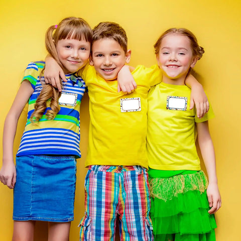 Three kids wearing 180 pieces boho name tag stickers for classroom use dope heart and polka dot labels for teachers and students
