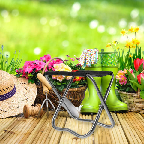 Grab And Go Portable Folding Stool And Camping Bench silver, shown in a garden setting with flowers and gardening tools.