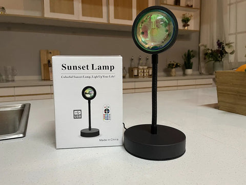 Sunset Lamp Projector With RGB LED Lights on kitchen counter, showing app and remote-controlled features, product box visible