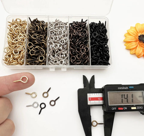 Sweet Gear Mini Screw Eye Hooks Rolling As A Hella Thick 750 Piece Multicolor Stash Built Tough For Easy DIY Jewelry Making Resin Crafts And Hanging Lightweight Parts in a clear box with various colors.