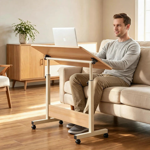 Rolling Laptop Standing Desk With Adjustable Tilting Tabletop And Smooth Locking Casters Lightweight Foldable Computer Workstation For Lowkey Work From Home Vibes In Compact Dorm Or Apartment Spaces, used by a man on a sofa.