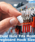 Hand holding clear pegboard clip in front of red-handled tools on a retail display. Clear Pegboard Clips For 1/4 Peg Hooks And Slatwall No Fuss Inventory Clips Peg Locks For Retail Hooks On Peg Board And Slat Wall Panels Ideal For Store Displays 100 Pack.