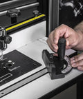 Rock Solid Free Standing Router Table With Heavy Duty Steel Base And Spacious 24 By 16 Inch Laminated Top Built Like A Tank For Precision Cabinet Work Featuring Smooth Aluminum Fence System angle view showing adjustment tool on the work surface.