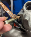 Applying Copper Anti-Seize Compound With Micro Fine Copper Flakes In A Semi-Synthetic Grease Carrier 454 g to threaded fastener.