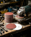 100 Pack 3 Inch 80 Grit Sanding Discs With Hook Loop Backing For Drills And Grinders on a workbench with tools.