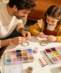 Father and daughter making bracelets with colorful beads on a table, next to a Beading And Pliers Organizer Tray For Desktop And Workbench Tools Multi Slot Pliers Storage Rack For Garage Cabinet Mechanic Shop Easy Grab And Go Secure Hold Keeps Tools Neat And Accessible.