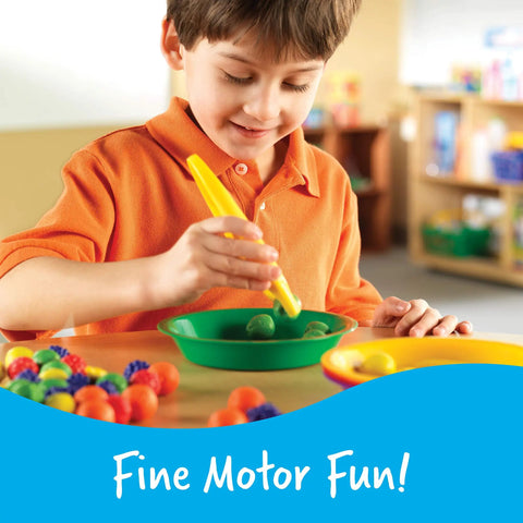 Child using jumbo tweezers for fine motor play with colorful sensory bin tools, Montessori grabber for hands-on learning