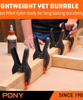 Heavy Duty Nylon Spring Clamp Set With Adjustable Jaw Pads, four clamps securing wood on workbench.