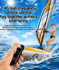 Mini Remote Control Boat With 2.4GHz RC Windsurfer Surfing Action shown on ocean with person holding remote