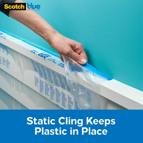 Applying Paint Tape With Plastic Duo That Clings For Easy Positioning And No Residue Finish on wall edge over taped masking film.