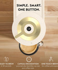 Top view of Vertuo Next Coffee And Espresso Maker By DeLonghi In Creamy White With Gold, one-touch brewing button and a cup of coffee.