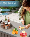 Woman using 120-Quart Patio Cooler With Wheels, Rollable Outdoor Ice Chest With Bottle Opener, Collapsible Side Shelf And Drain Rack, Stainless Steel Lid, Party Ready For BBQs, Camping And Backyard Gatherings, Brown as prep surface.