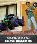 Boy playing with Grave Digger 1 15 Scale Remote Control Monster Truck For Indoor And Outdoor Play Smash And Bash RC Car in yard.
