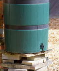 Green rain barrel with a Three Quarters Inch PVC Bulkhead Fitting With Four Millimeter Silicone Seal Gasket for leak-proof water connection.
