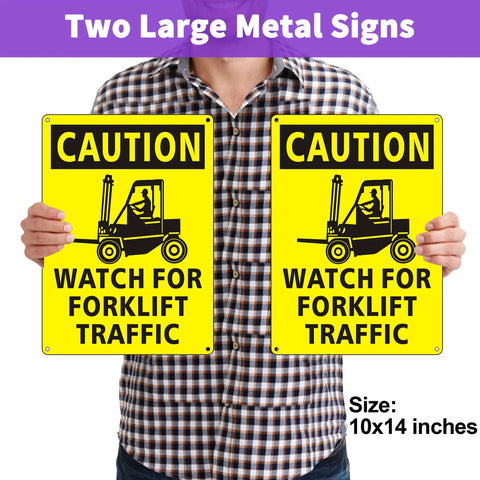 Person holding two yellow 'Watch for Forklift Traffic' safety signs, 10x14 inches each with caution graphic.