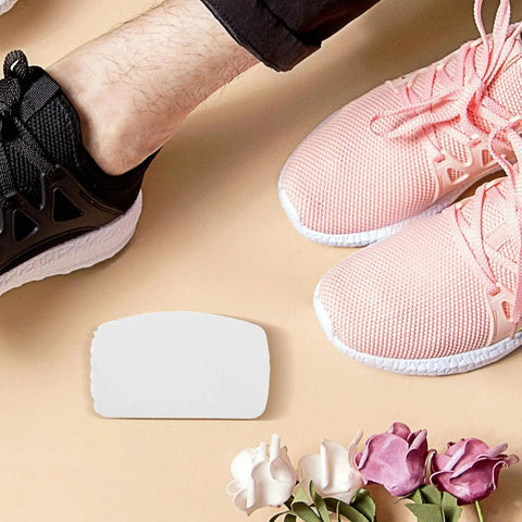 10Pk Self Adhesive Sneaker Heel Repair Patches on the floor next to pink and black running shoes, ideal for shoe repair.