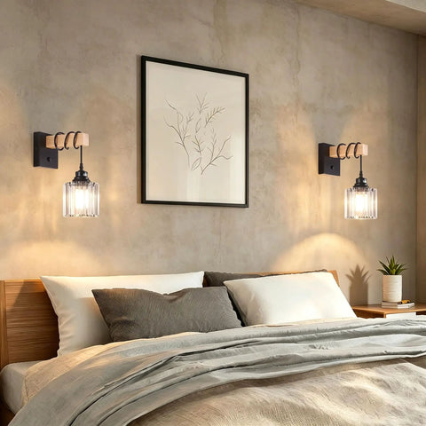 BANGANMA 2-Pack Black Farmhouse Hardwired Wall Sconces Crystal for Bathroom with clear crystal shade beside a bed.