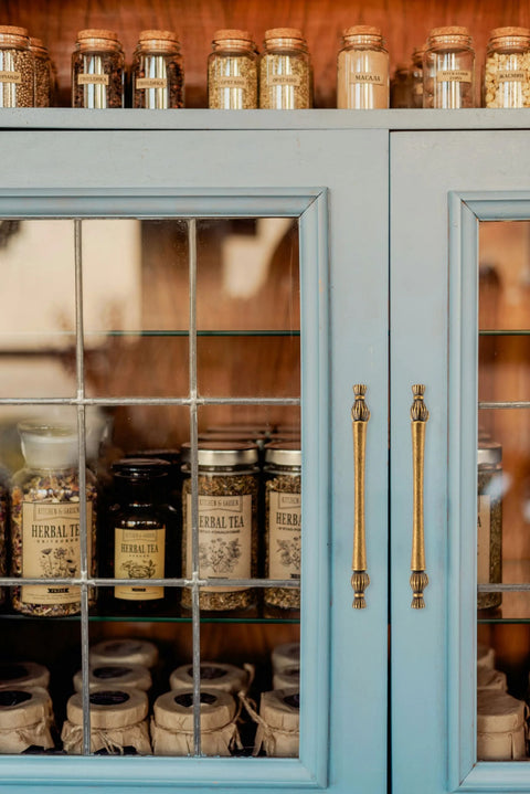 Close-up of a blue cabinet with 10 Pack 3 Inch Hole Centers Antique Brass Cabinet Pulls Vintage Brass Cabinet Hardware in a kitchen setting.
