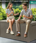 Two people sitting on Massive 220 Gallon Outdoor Storage Deck Box With Divider Waterproof Lockable Resin Built Wood Look Brown.
