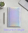 A glitter bubble mailer from a 30 pack, tear resistant shipping bag for jewelry, makeup, gifts, and small items, on a desk.