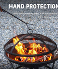 Person using poker with 22 Inch Outdoor Fire Pit With Mesh Lid And Log Grate For Backyard Deck Camping And Picnics Durable Steel Construction
