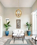 Gold Orb Three Light Chandelier With Adjustable Ring Orbits Modern Globe Hanging Lights Fixture over patio seating area