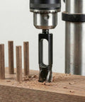 Five Piece High Carbon Steel Wood Plug Cutter Set Offering 3/8 To 1 Inch Bits For Smooth Dowel Plugging And No Nonsense Woodworking Gear That Gets It Done Right in use, drilling wood with cut dowels visible.