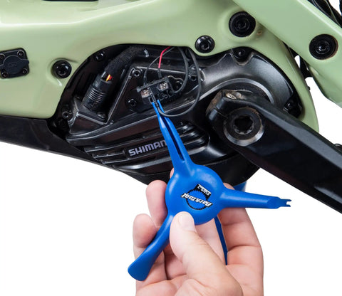 Using the EWS-2 Bicycle Electronic Shift Tool For Shimano EW-SD3000 Wires And Batteries on bike gear, blue tool in hand.