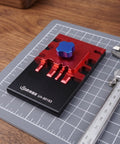 Metal Etching Sheet Bender Tool for Photo Etched Parts and Model Assembly on a grid mat with caliper nearby