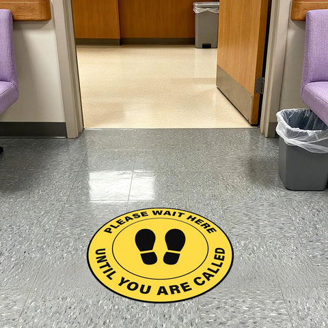 10 Pack Please Wait Here Until You Are Called Sign 12 Inch Square Vinyl Floor Sign in yellow on hospital waiting room floor