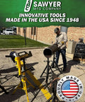 Worker using industrial equipment with Sawyer MFG branding at an outdoor site, highlighting innovative tools made in the USA.