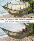 Heavy Duty Camping Hammock With Built-In Mosquito Net, 500 Lb Capacity on a beach with couple inside.