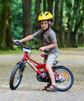 Child riding a red bike on a forest path, using two heavy duty 14 inch bike inner tubes with Schrader valve 45/57-254.