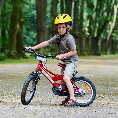 Child riding a red bike on a forest path, using two heavy duty 14 inch bike inner tubes with Schrader valve 45/57-254.