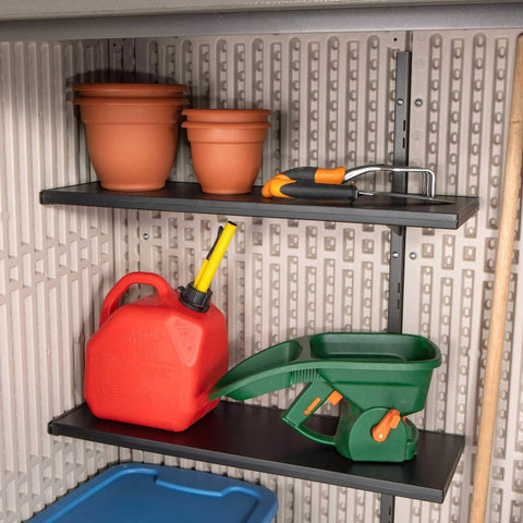 Interior of Vertical Storage Shed Desert Sand With Lockable Doors And Weather Resistant Resin Panels, shelves with garden tools.
