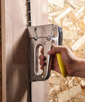 Heavy Duty Staple Gun With Rear Load Magazine For Voice And Data Cables And Wiring in use against a wood panel