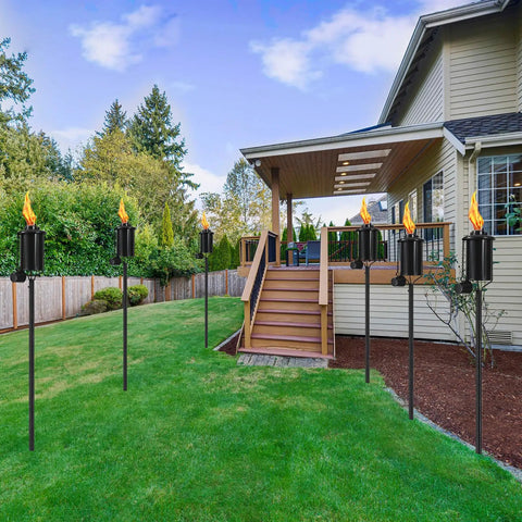 Outdoor Citronella Metal Torch Set Of 4 16 Oz Each Adjustable 59 Inch Garden Torches installed in a backyard pathway