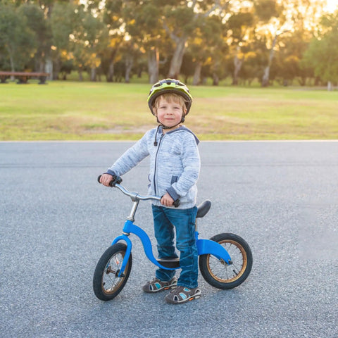 Child on blue balance bike with Kid Bike Seat Replacement Cushion for 12 and 14 Inch Balance Bikes, in park.