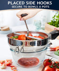 Hand using Pro Grade Stainless Steel Food Mill With 3 Milling Discs for tomatoes, secured with side hooks over a glass bowl.