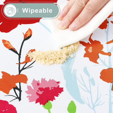 Close-up of hand wiping crumbs off flower print All-in-One Picnic Table Cover Set With Bench Covers For 6 Foot Tables.