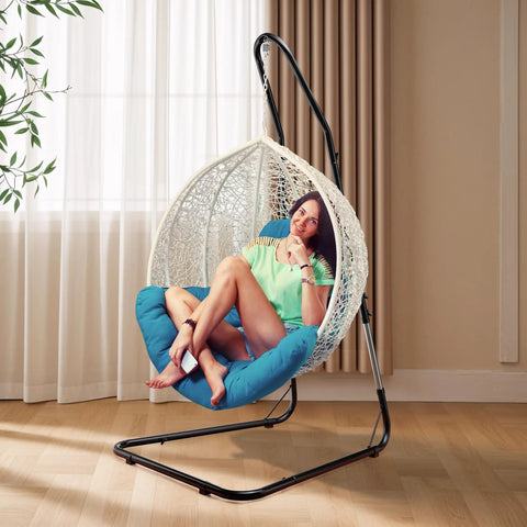 Woman sitting in heavy duty hammock chair stand with adjustable steel frame, weatherproof and rust resistant, indoor setting.