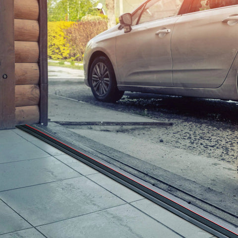 20 Foot PVC Rubber Garage Threshold Seal With Raised Edge And Red Safety Strip installed at garage entrance, blocking debris.