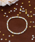 bracelet on brown surface with scattered 4mm mini metal daisy spacer beads bulk 600pcs silver and gold for DIY bracelets and necklaces