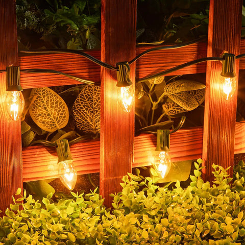 Lit Outdoor 50 Feet LED Globe String Lights With 25 Bulbs Energy Saving Waterproof Hanging Lights mounted on a wooden fence.