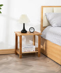 Solid Acacia Wood Side Table With Two Tier Storage For Indoor And Outdoor Use No Fuss Assembly End Table For Living Room And Patio Weather Resistant Light Natural Rustic Finish shown by a bed